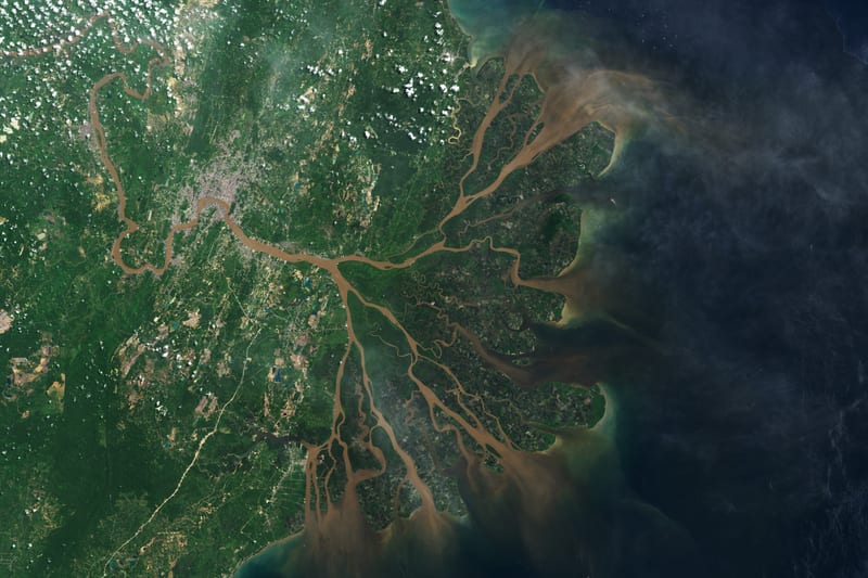 Citra satelit Delta Mahakam dengan banyak cabang sungai berwarna cokelat yang mengalir ke Selat Makassar.